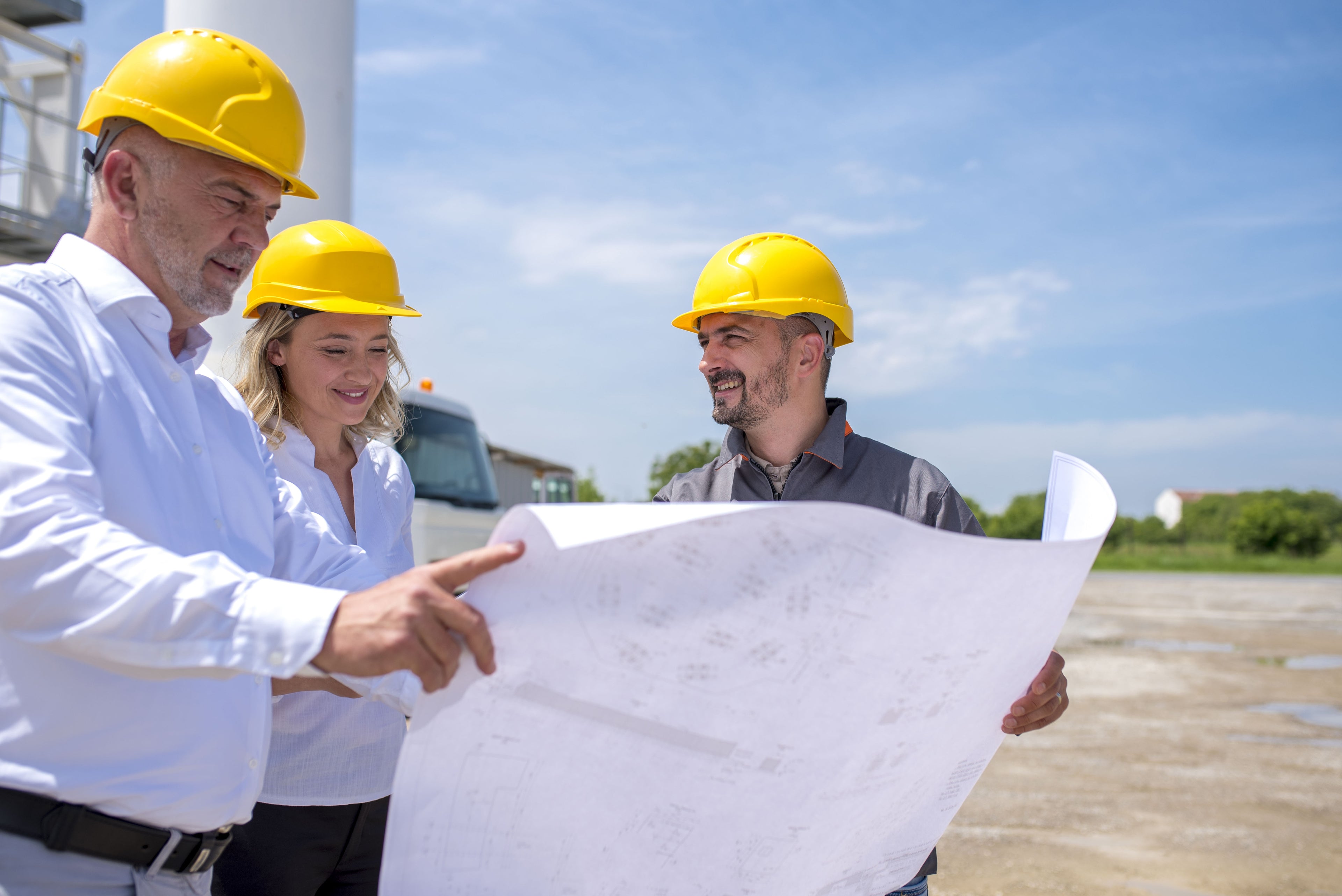 Contractors reviewing blueprints for my house at construction site